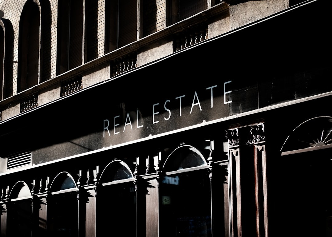 A real estate sign displayed on a historic brick building.